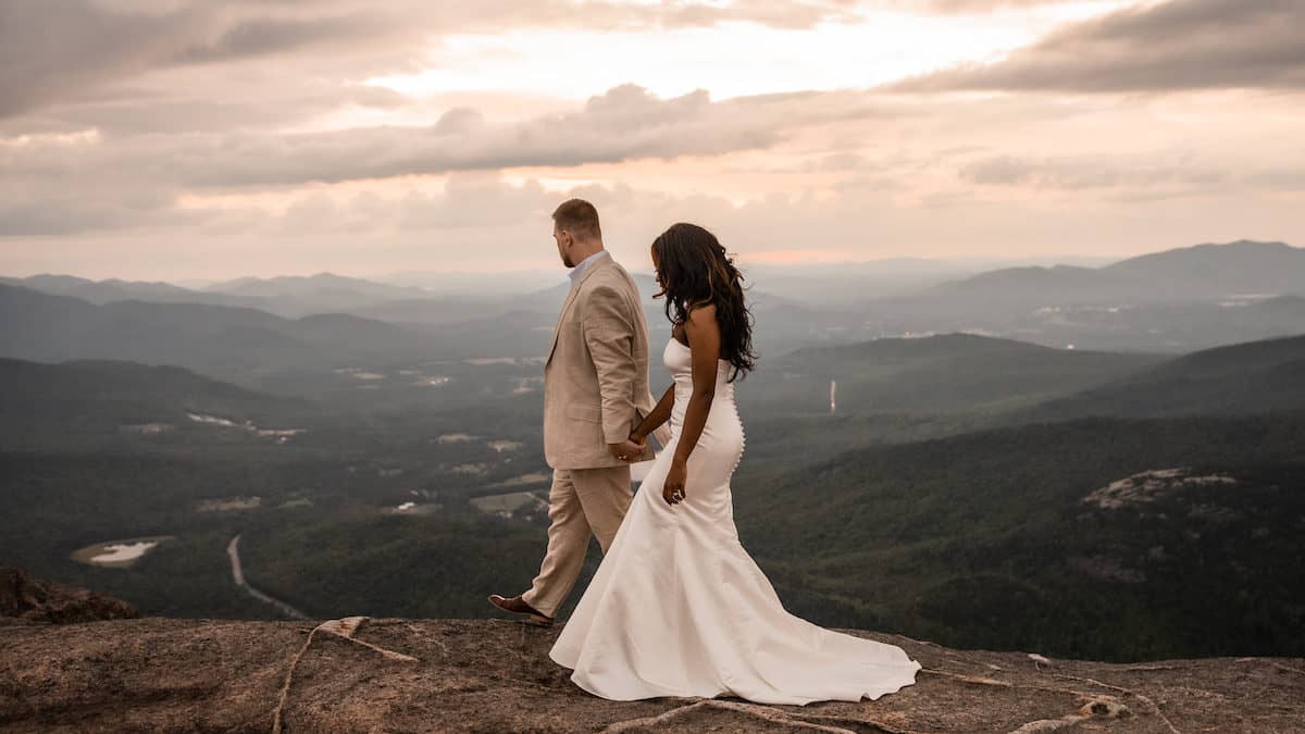 Couple eloping on Cascade Mountain in Lake Placid, New York at sunset overlooking the Adirondack Mountains