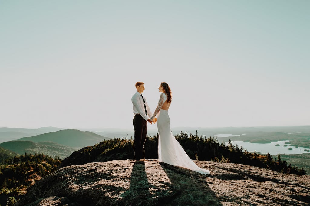 Coupling holding hands on a mountaintop, eloping without their family
